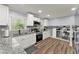 Modern kitchen featuring white cabinetry, granite countertops, stainless steel appliances, and hardwood flooring at 5916 Simone Dr, Stone Mountain, GA 30087