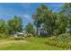 Large backyard with mature trees, detached building, manicured lawn, and landscaped garden at 1000 Nw Main St, Conyers, GA 30012