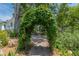 Backyard archway covered in greenery with stone paver pathway and water fountain in the distance at 1000 Nw Main St, Conyers, GA 30012