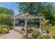 Charming backyard pergola with outdoor seating, surrounded by lush landscaping and flowers at 1000 Nw Main St, Conyers, GA 30012
