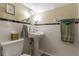 Cozy powder room featuring a pedestal sink, classic subway tile and decorative details at 1000 Nw Main St, Conyers, GA 30012