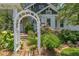 Charming home exterior with a stone walkway, lush landscaping and a decorative white arbor at 1000 Nw Main St, Conyers, GA 30012