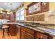 Close-up of kitchen sink with granite countertops, wood cabinets and stainless steel dishwasher at 1000 Nw Main St, Conyers, GA 30012
