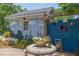 Charming garden outbuilding with a mural, surrounded by flowers and a stone table at 1000 Nw Main St, Conyers, GA 30012