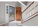 Bright foyer with wood-look floors, showcasing a staircase and beautiful wood front door with sidelight at 108 Kelly Ct, Dallas, GA 30157