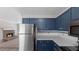 Well-equipped kitchen with stainless steel appliances, navy cabinets, and a view into the adjacent living room at 108 Kelly Ct, Dallas, GA 30157