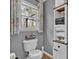 Cozy bathroom featuring a toilet next to a window and decorative storage shelf at 127 Hyde Way, Dallas, GA 30157