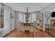Bright dining area featuring a chandelier, light wood floors and large windows with white curtains at 127 Hyde Way, Dallas, GA 30157