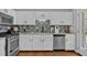 Bright kitchen with white cabinets, stainless steel appliances, updated backsplash and granite countertops at 127 Hyde Way, Dallas, GA 30157
