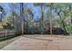 A backyard deck with wood railing, a small grassy area, and the trees in the backyard beyond at 2697 Links Overlook Drive Dr, Dacula, GA 30019