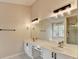 Bathroom showcasing dual sinks, modern lighting, large mirror and a glass shower with a tub nearby at 2697 Links Overlook Drive Dr, Dacula, GA 30019
