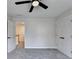 This is a neutral bedroom with a ceiling fan, carpet, natural light, and access to a hallway at 2697 Links Overlook Drive Dr, Dacula, GA 30019