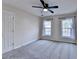 This bedroom features plush gray carpeting, a modern ceiling fan, and plenty of natural light from the two windows at 2697 Links Overlook Drive Dr, Dacula, GA 30019