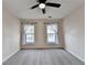 Spacious bedroom featuring neutral paint, soft carpet, a fan, and two windows with natural lighting at 2697 Links Overlook Drive Dr, Dacula, GA 30019