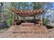 The wood pergola is covering the hot tub with built in benches on a raised platform deck at 2697 Links Overlook Drive Dr, Dacula, GA 30019