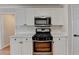 Close-up of the kitchen with stainless steel gas range and stylish white cabinets at 2697 Links Overlook Drive Dr, Dacula, GA 30019