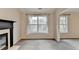 Living room featuring a fireplace, large windows with natural light, and neutral colored carpet and walls at 2697 Links Overlook Drive Dr, Dacula, GA 30019