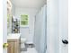 Bathroom features a wood vanity, shower with curtain and a window for natural light at 5115 Cascade Palmetto Hwy, Fairburn, GA 30213