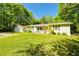 Well-maintained home with a detached garage and green lawn, surrounded by mature trees and lovely landscape at 5115 Cascade Palmetto Hwy, Fairburn, GA 30213