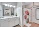 Bright bathroom with a large mirror, white cabinetry, and decorative shower curtain at 3040 Peachtree Nw Rd, Atlanta, GA 30305