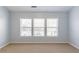 Neutral carpeted bedroom featuring three large windows that provide ample natural light at 2496 Gristhaven Ln, Buford, GA 30519