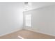 A simple bedroom features neutral carpet, white walls, and a window, creating a bright and adaptable space at 2496 Gristhaven Ln, Buford, GA 30519
