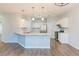 Well-lit kitchen with granite countertops, stainless steel appliances, and wood flooring at 2496 Gristhaven Ln, Buford, GA 30519