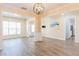 Open-concept living room showcasing abundant light, wood floors and access to other rooms at 2496 Gristhaven Ln, Buford, GA 30519