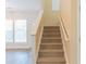 Carpeted stairs with white railings lead to the upper level of the home at 2496 Gristhaven Ln, Buford, GA 30519