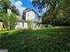 View of the backyard with mature trees and lush lawn at 3053 Herscu Way, Stonecrest, GA 30038