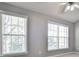 Neutral bedroom featuring a ceiling fan, carpeted floors and two large windows with natural light at 1126 Village Se Ct, Atlanta, GA 30316