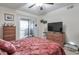 Comfortable bedroom featuring a private balcony, and a TV, illuminated by a ceiling fan at 2937 Torreya Way, Marietta, GA 30067