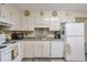 Traditional kitchen featuring white cabinetry, appliances, and decorative backsplash at 2937 Torreya Way, Marietta, GA 30067