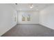 A large, naturally lit bedroom featuring neutral carpeting, a ceiling fan, and two windows at 364 Poplar Springs Rd, Hiram, GA 30141