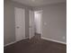 Clean room painted in neutral tones features an open closet and carpet, creating a versatile space at 4952 Isle Royal Ct, Stone Mountain, GA 30088