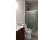 Modern bathroom featuring a vanity, toilet, and tiled walk-in shower with sliding glass door at 8155 Stone Hill Rd, Cumming, GA 30028