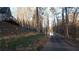 Long driveway surrounded by mature trees leading to the home and lake at 8155 Stone Hill Rd, Cumming, GA 30028