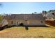 The backyard features a large grassy area, patio, and mature trees offering lots of privacy at 892 Creek Bottom Rd, Loganville, GA 30052