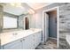 This bathroom features double sinks, a large mirror, and wood-look tile floors and walls at 892 Creek Bottom Rd, Loganville, GA 30052