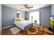 This bedroom has a comfortable bed, a mirror, and a window that overlooks a landscaped yard at 892 Creek Bottom Rd, Loganville, GA 30052