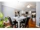 Bright dining area with square glass-top table, comfortable seating, with view to kitchen and entry at 892 Creek Bottom Rd, Loganville, GA 30052