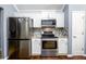 Kitchen with stainless steel appliances, white cabinets, and mosaic tile backsplash at 892 Creek Bottom Rd, Loganville, GA 30052