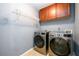 Laundry room with side-by-side front-load washer and dryer, storage, and wire shelving at 892 Creek Bottom Rd, Loganville, GA 30052
