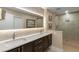 Elegant bathroom featuring dual sinks, granite counters, a large mirror, and a glass shower with tile surround at 2660 Peachtree Nw Rd # 14D, Atlanta, GA 30305