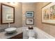 A powder room features a vessel sink, granite counter, elegant wallpaper, and traditional artwork at 2660 Peachtree Nw Rd # 14D, Atlanta, GA 30305