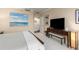 Comfortable bedroom featuring a bed with white linens, neutral walls, carpeted floors, and a large TV at 2660 Peachtree Nw Rd # 14D, Atlanta, GA 30305
