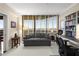 A large office is complete with a sofa, desk, custom bookshelves, and city views at 2660 Peachtree Nw Rd # 14D, Atlanta, GA 30305