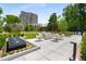 An outdoor patio with comfortable seating, fire feature, manicured green spaces, and a view of the building and surrounding greenery at 2660 Peachtree Nw Rd # 14D, Atlanta, GA 30305