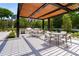 An outdoor dining and grilling area under a pergola, complete with tables, chairs, and landscaping at 2660 Peachtree Nw Rd # 14D, Atlanta, GA 30305