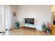 Bright living room with hardwood floors, sheer curtains, plants, and a modern TV stand at 112 Rogers St # 409, Atlanta, GA 30317